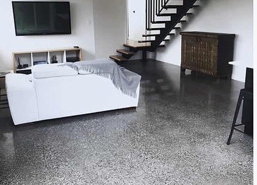 Polished concrete floor in an open-plan Melbourne living room with floating staircase